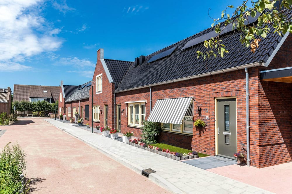 Rij nieuwbouwwoningen in baksteen, met luifels en houten kozijnen
