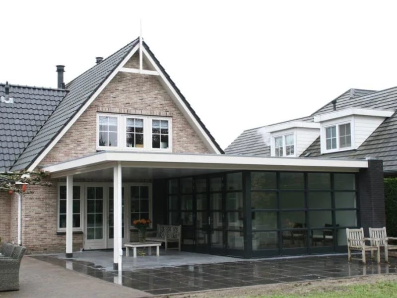 Aanbouw met een rij openslaande deuren onder een luifel
