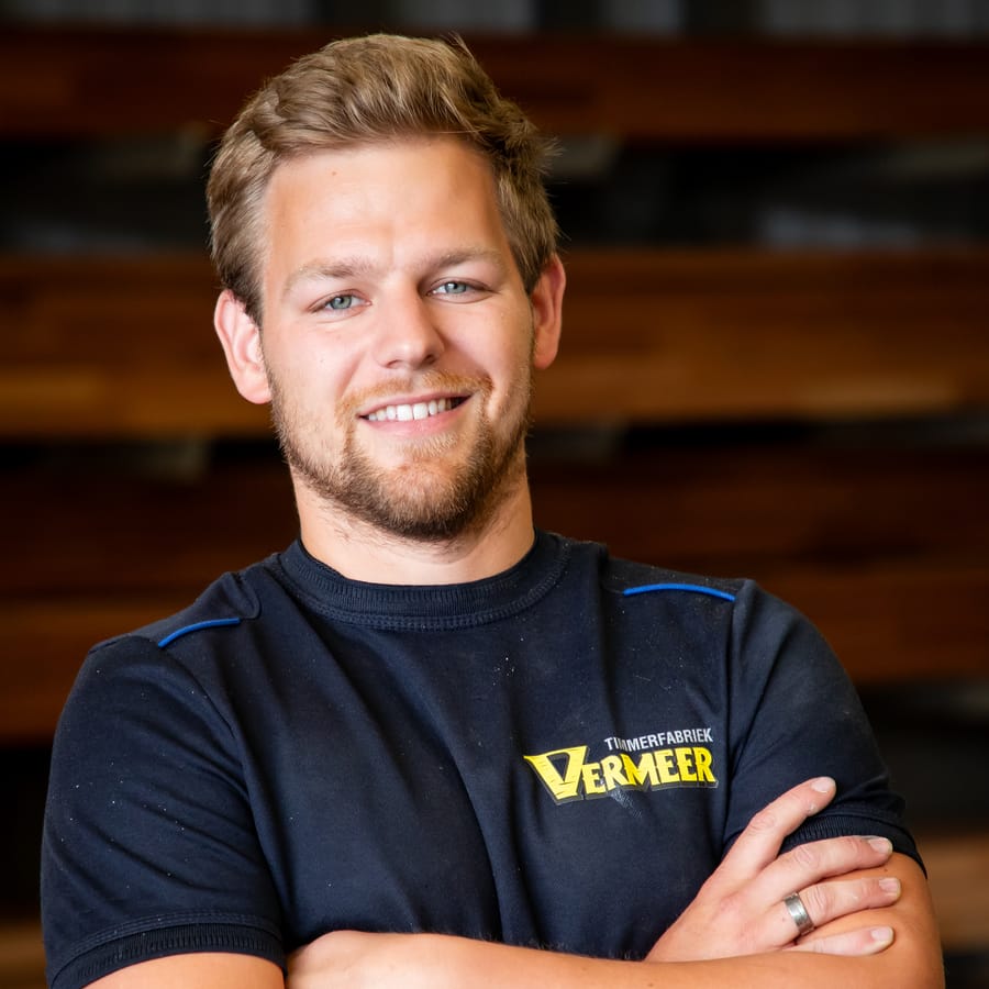 Sander, lachend met de armen over elkaar in de fabriekshal